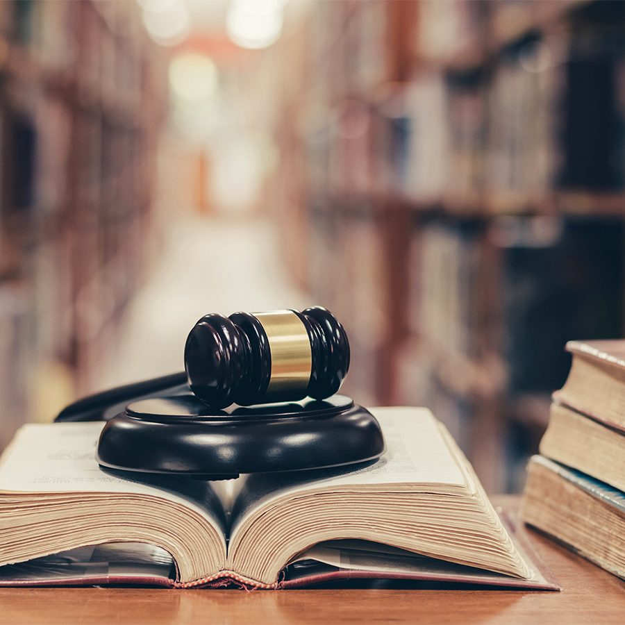 World book and copyrights day and international legal rights concept with old book in library with judge gavel on open law textbook in court archive text collection study room