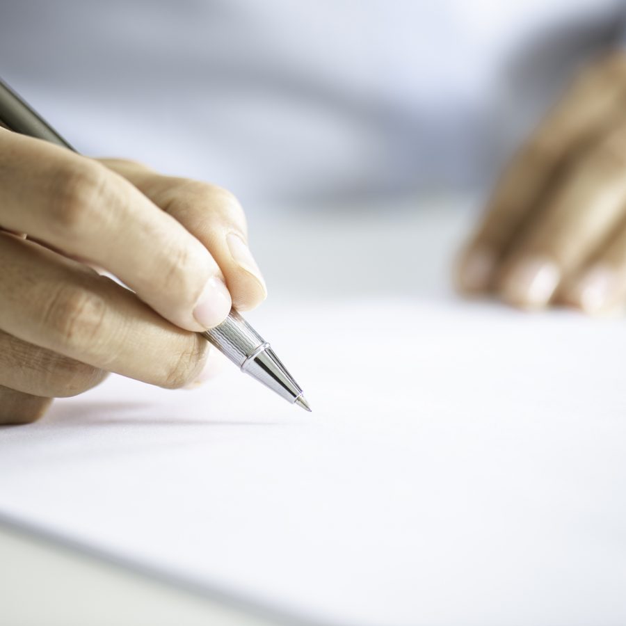 Close up of an unrecognizable businessman signing contract paper.